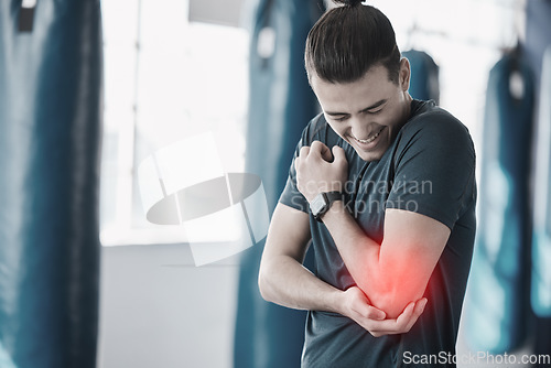 Image of Hand, elbow pain and injury with the arm of a man in red highlight during a fitness workout. Healthcare, medical and emergency with a young male athlete holding a joint after an accident in the gym