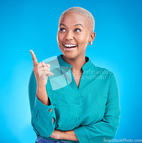 Image of Excited, direction and happy black woman point at studio logo design, commercial choice or announcement news. Service smile, brand info and African person gesture at discount deal on blue background