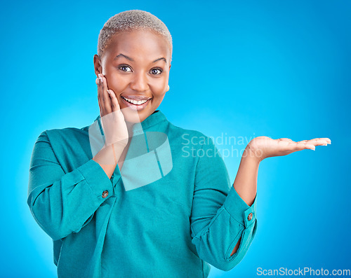 Image of Portrait, smile and black woman showing, presentation and promotion against a blue studio background. Face, female person or model with discount deal, option and choice with decisions and advertising