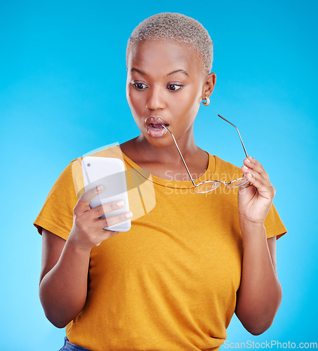 Image of Shocked, wow and woman reading phone for fake news, wrong email and mistake or scam email. Surprise, stress and african person or online user, social media or mobile problem in studio blue background