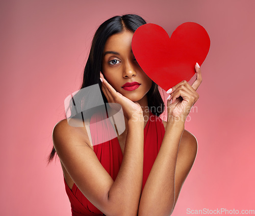 Image of Woman, paper heart and face in studio portrait for makeup, beauty or romantic sign by red background. Girl, fashion model and cardboard emoji with love for cosmetic, valentines day date and aesthetic