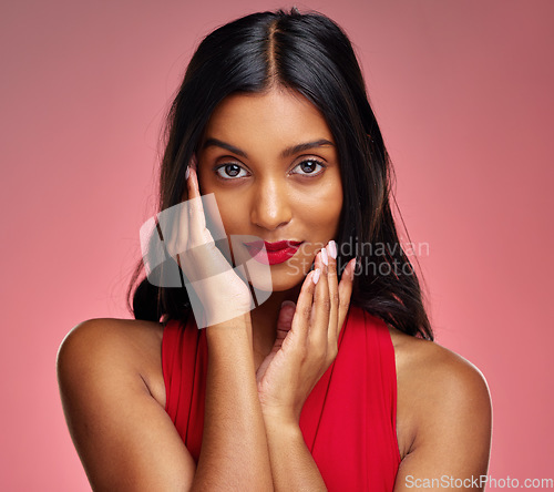 Image of Woman, red lipstick and beauty, hands touching face with makeup and cosmetics glow on pink background. Cosmetology, Indian female model in portrait and shine with wellness and skincare in studio