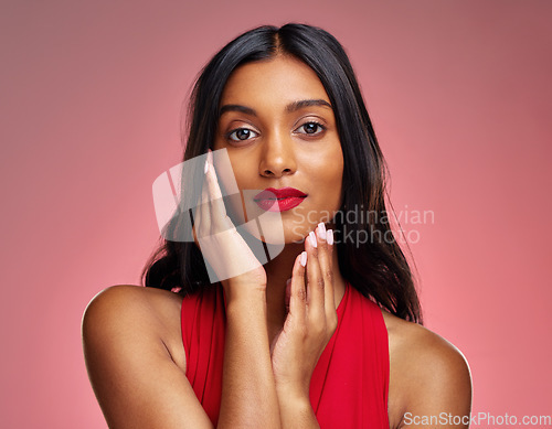 Image of Woman, portrait and face with makeup on valentines day for beauty against a studio background. Female person or model touching perfect skin in facial treatment, cosmetics or skincare of lady in red