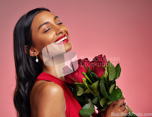 Image of Face, beauty and smile of a woman with a roses on a studio background for valentines day. Makeup, model and happy young Indian girl with a flower bouquet for romance or love on a pink backdrop