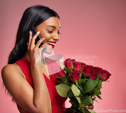 Image of Phone call, talking and a woman with roses on a studio background for valentines day. Thank you, model and face of a young Indian girl with a flower bouquet and smartphone for romance or love on pink