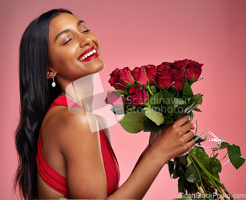 Image of Happy, beauty and face of a woman with a roses on a studio background for valentines day. Makeup, model and young Indian girl with a flower bouquet and laugh for romance or love on a pink backdrop