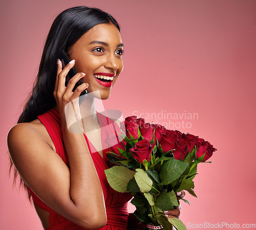 Image of Phone call, laugh and a happy woman with roses on a studio background for valentines day. Smile, model and face of a young Indian girl with a flower bouquet and smartphone for romance, chat and love