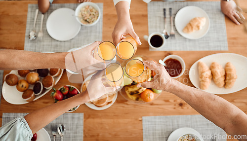 Image of Lunch, hands and people toast with orange juice, beverage or glass drinks at lunch, brunch or food meal. Fruit liquid, top view group and home family solidarity, celebrate and cheers at social event