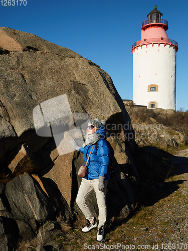 Image of Beautiful woman posing near lighthouse. Travel the world concept