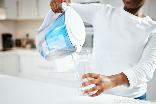 Image of Person, jug and glass of filter water in kitchen for fresh drink, liquid and hydration. Closeup, thirsty woman or pouring pure aqua beverage in container for nutrition, drinking or filtration at home