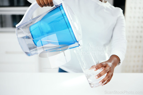 Image of Hands, jug and glass of filter water to refresh with pure liquid hydration at home. Closeup, thirsty person and pouring healthy aqua beverage in container for nutrition, drinking and cold filtration