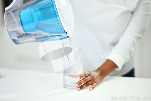 Image of Hands, person and pitcher of filter water, glass and liquid hydration for purification at home. Closeup, thirsty woman and pouring healthy aqua beverage for nutrition, drinking and clean filtration