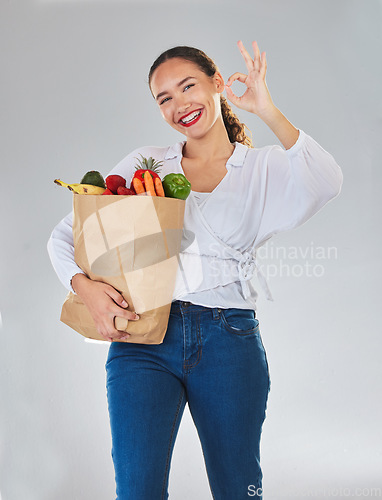 Image of Groceries, okay sign and woman in portrait with food excellence and promotion, sale or discount. Person, bag and grocery shopping, healthy fruits and vegetable and ok emoji on studio white background