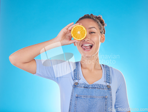 Image of Portrait, tongue out and woman with orange in studio isolated on a blue background. Face, fruit and person with food for healthy diet, nutrition or wellness, eating and vitamin c, benefits and vegan.