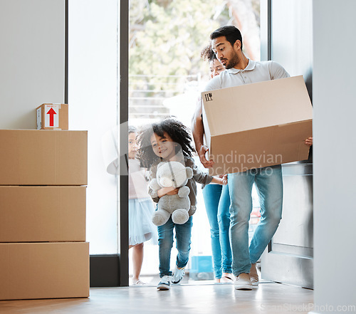 Image of Happy family, box and moving in new home for real estate, property investment or mortgage loan by door. Father, mother and children walk in house with package for relocation, renovation or start life