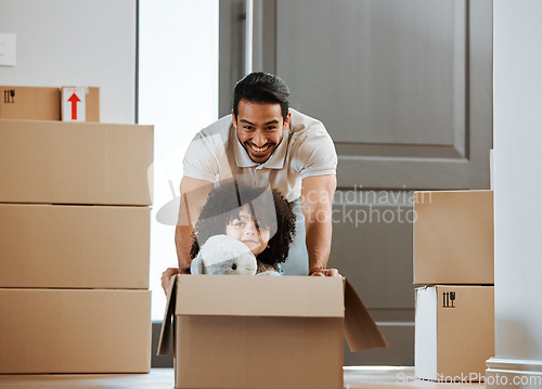 Image of Father, child and fun with box while moving to new home, real estate and property of house. Happy dad, kid and ride in cardboard while packing, playing games and celebration of relocation or freedom