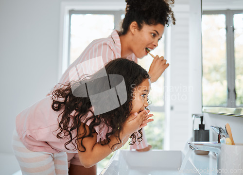 Image of Mom, girl cleaning teeth and together in bathroom with toothbrush, toothpaste and morning routine in family home. Kid, mother and brushing tooth for hygiene, grooming and teaching healthy dental care