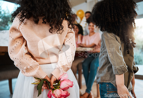 Image of Flowers, back surprise and family at a birthday celebration with children and hiding a gift together. Love, mothers day or kids giving a floral present at a home party for parents or grandparents