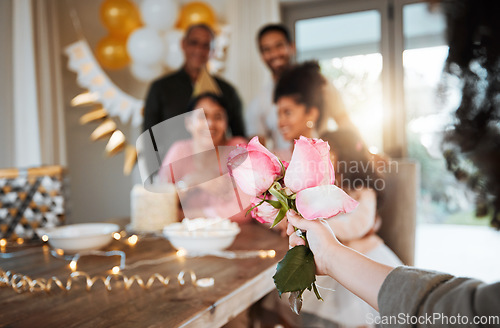 Image of Roses, family and hand with a gift for a celebration at a birthday, mothers day or party in a house. Giving present, love and a child with flowers for women or grandmother to celebrate mothers day