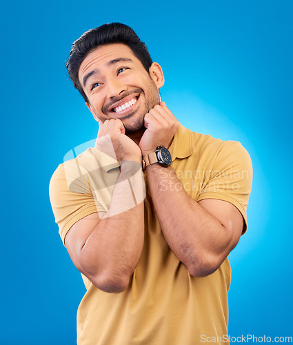 Image of Happy, smile and man in studio with a dreaming or sweet memory or future facial expression. Happiness, excited and male model from India with positive mindset for planning isolated by blue background