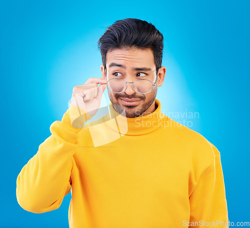 Image of Thinking, glasses and Asian man with ideas, decision and emoji against a blue studio background. Male person, model and guy with eyewear, opportunity or choice with solution, focus or problem solving