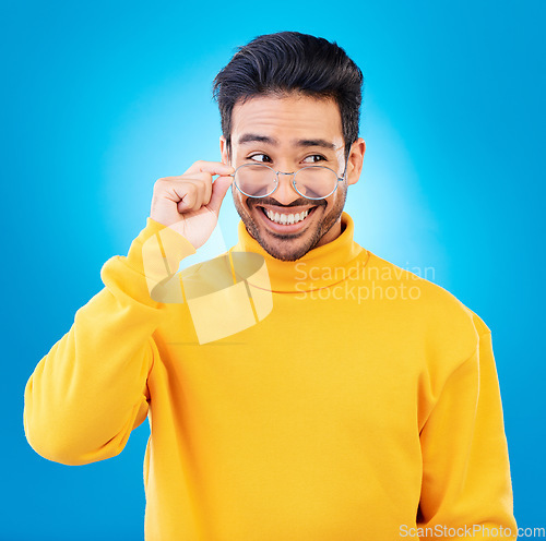 Image of Thinking, glasses and Asian man with ideas, solution and happiness against a blue studio background. Male person, option and model with eyewear, opportunity or choice with a smile and problem solving