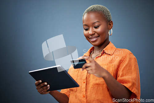 Image of African woman, credit card and tablet in studio for e commerce, digital payment or smile by background. Girl, touchscreen and fintech with online shopping, bills or cybersecurity with typing password