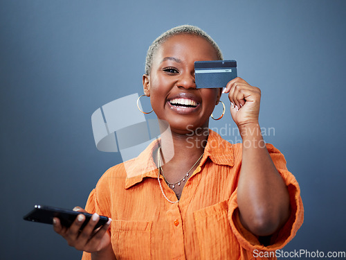 Image of Portrait, phone and credit card with a black woman online shopping in studio on a gray background. Mobile, ecommerce and funny humor with a young female shopper looking excited for a deal or sale