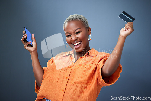 Image of Winner, phone and credit card with a black woman online shopping in studio on a gray background. Mobile, ecommerce and wow with a happy young female shopper in celebration of deal or sale success