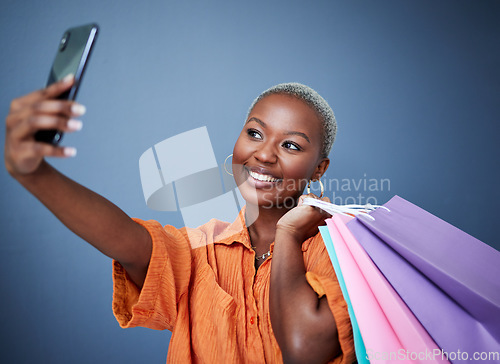 Image of Selfie, happy and woman with shopping bags in studio after sale, promotion or discount. Smile, excited and African female person or customer taking picture after buying products by gray background.