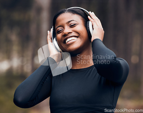 Image of Fitness, black woman listening to music and in woods with headphones happy for workout. Exercise or workout, training or happy and female athlete listen to radio or podcast for motivation in nature