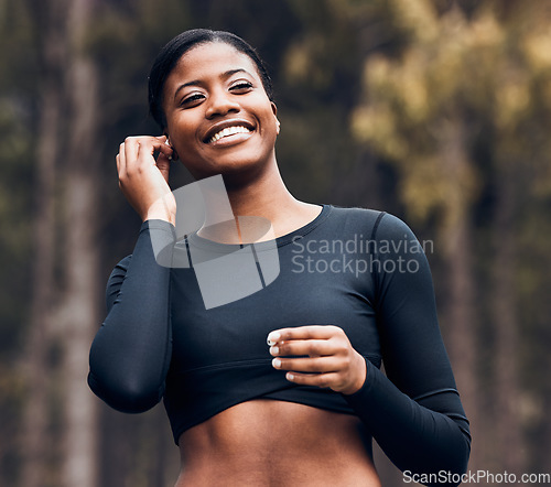 Image of Fitness, black woman listening to music and in nature with earphones happy for training. Exercise or workout, marathon and cheerful female athlete listen to radio or podcast for motivation in forest