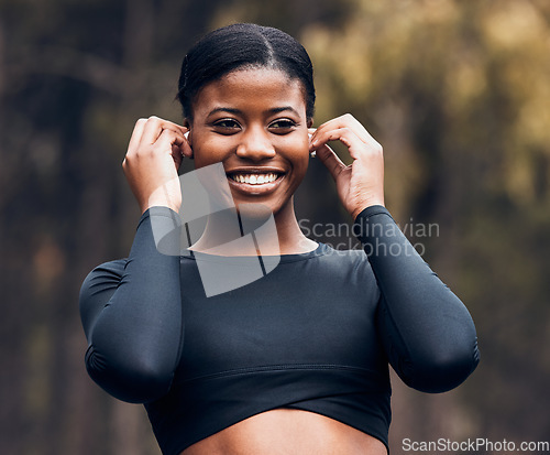 Image of Fitness, black woman listening to music and in forest with earphones happy for motivation. Training or workout, exercise or health wellness and female athlete listen to radio or podcast in woods