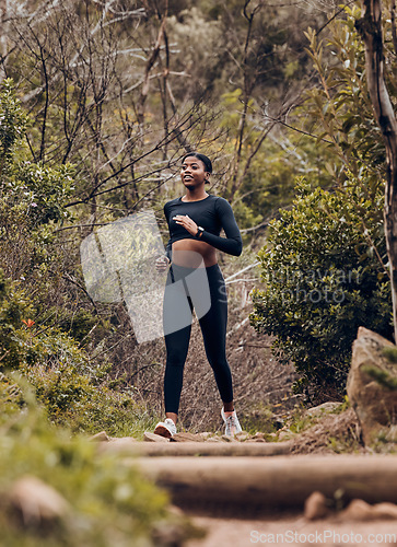 Image of Fitness, running and health with black woman in nature for workout, wellness and morning. Exercise, challenge and performance with female runner on forest trail for training, marathon and cardio