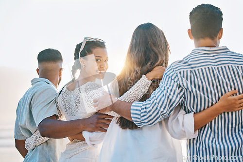 Image of Happy friends, back and hug on beach for sunset holiday, vacation or weekend together in nature. Rear view group of people standing for quality bonding time, trip or travel by the ocean coast outside