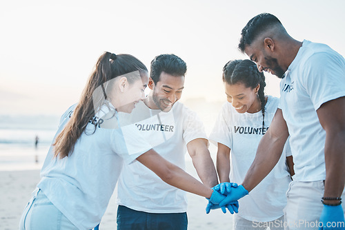 Image of Volunteering, team huddle and cleaning beach for world earth day, care for nature and environment. Help, recycle and support in teamwork, group of people at ocean to clean plastic waste and pollution