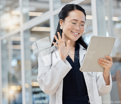 Image of Video call, wave and doctor with tablet in hospital lobby, digital communication and happiness in Japan. Smile, healthcare and hello, happy Asian woman in clinic with app for telehealth and medicine.