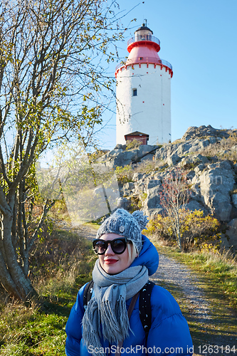 Image of Beautiful woman posing near lighthouse. Travel the world concept