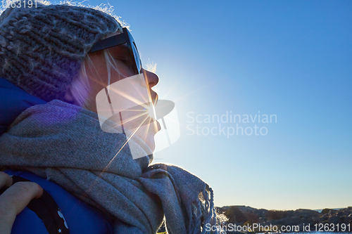 Image of Portrait a beautiful young woman in a woolen hat and the sun is shining from the mouth