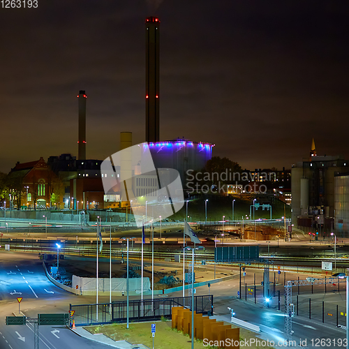 Image of Modern grain terminal at night. Metal tanks of elevator. Grain-drying complex construction. Commercial grain or seed silos at seaport. Steel storage for agricultural harvest