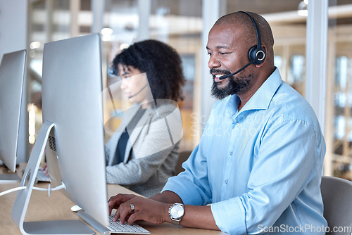 Image of Call center, black man and consultant at computer for customer service, business support or help in CRM office. Happy telemarketing agent typing at desktop for telecom consulting in coworking agency