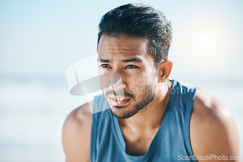 Image of Fitness, break and man breathing at the beach after training, running and intense cardio, focus and resting. Face, breathe and Mexican male runner stop to breathe during cardio workout at the sea