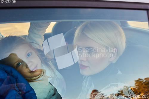 Image of Family concept. Portrait of mother and daughter through the glass of a car