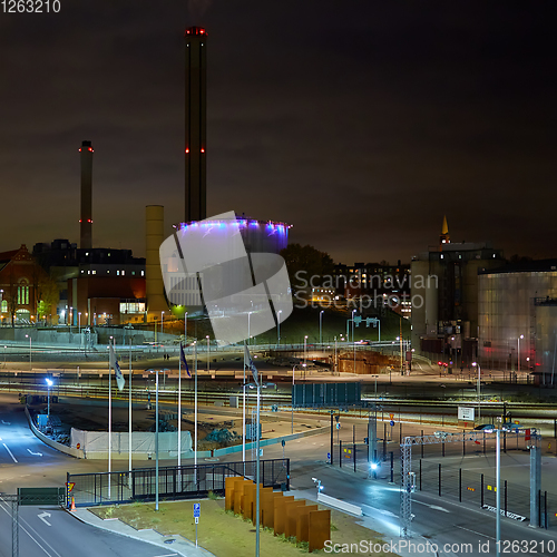 Image of Modern grain terminal at night. Metal tanks of elevator. Grain-drying complex construction. Commercial grain or seed silos at seaport. Steel storage for agricultural harvest