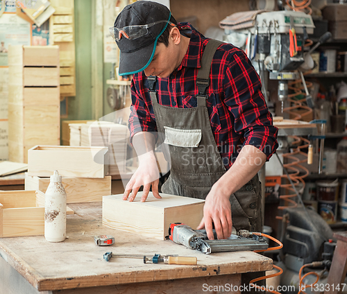 Image of The worker makes measurements of a wooden board