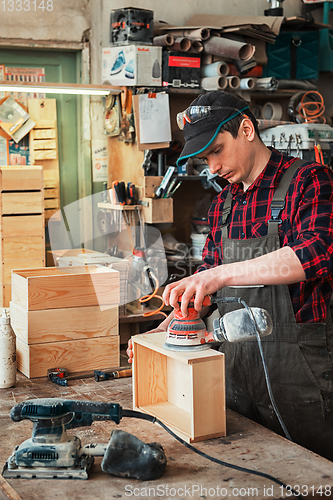 Image of Worker grinds the wood box