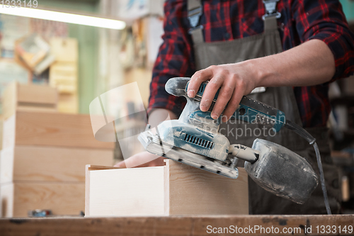 Image of Worker grinds the wood box