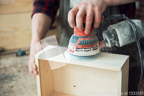 Image of Worker grinds the wood box