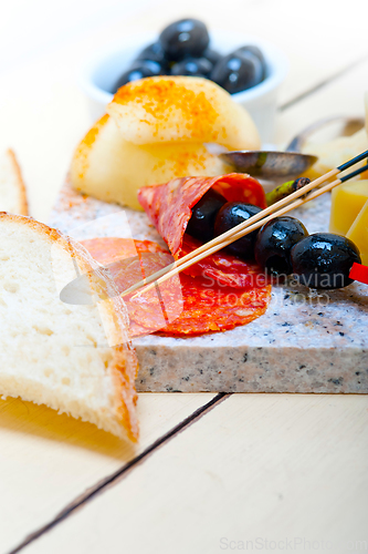 Image of mix cold cut on a stone with fresh pears