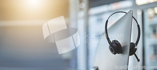 Image of Call center, headset on a computer in an empty office with flare and mockup for communication or assistance. Customer care, support and equipment in a workplace after hours for help or service